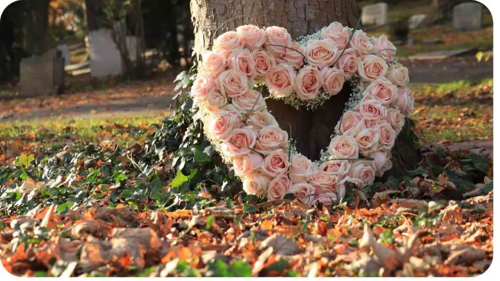 a heart shaped wreath of roses is placed in front of a tree