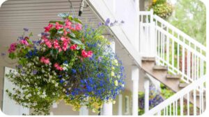 a hanging basket of flowers on the porch of a house