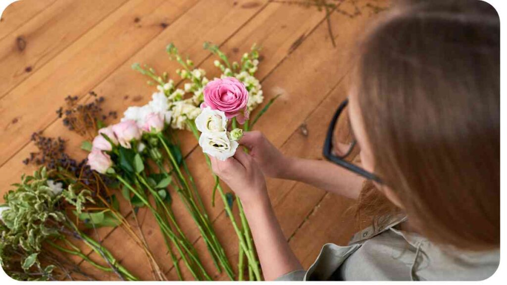 a person is arranging flowers on a wooden floor