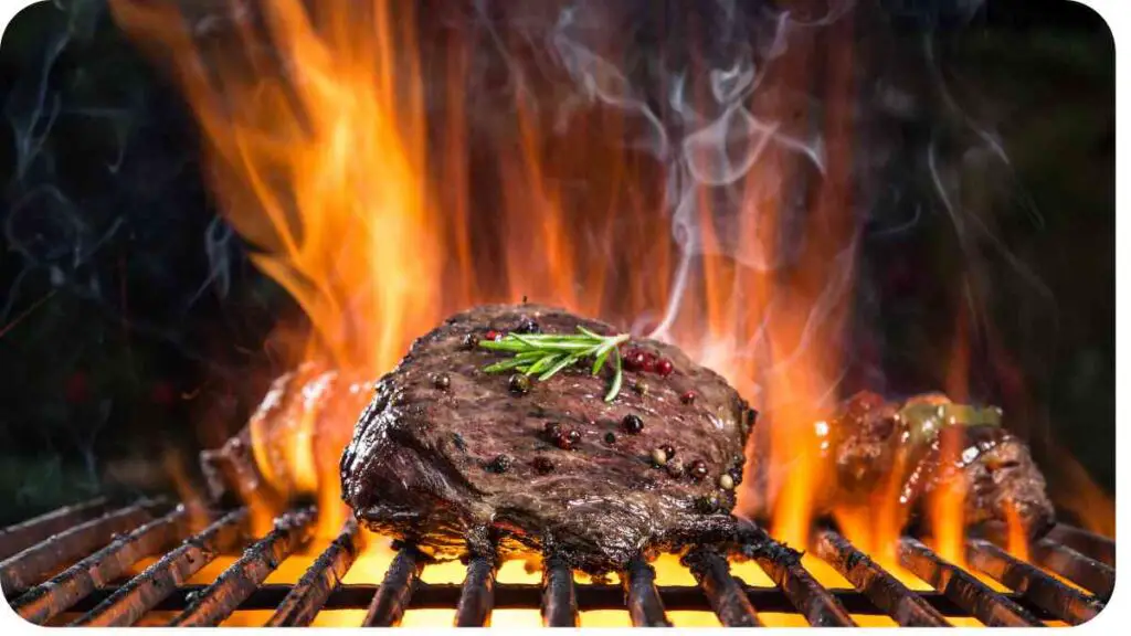 a steak on the grill with flames and smoke