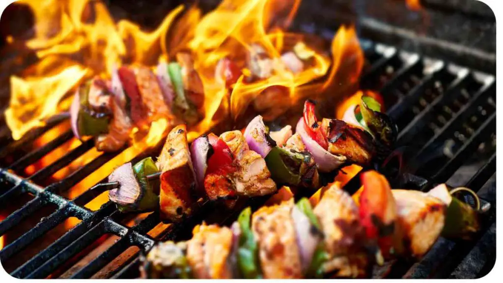 several skewers on a grill with flames and smoke