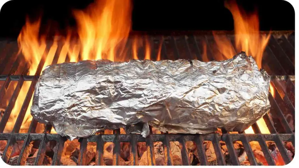 a piece of foil wrapped around a piece of meat on a grill