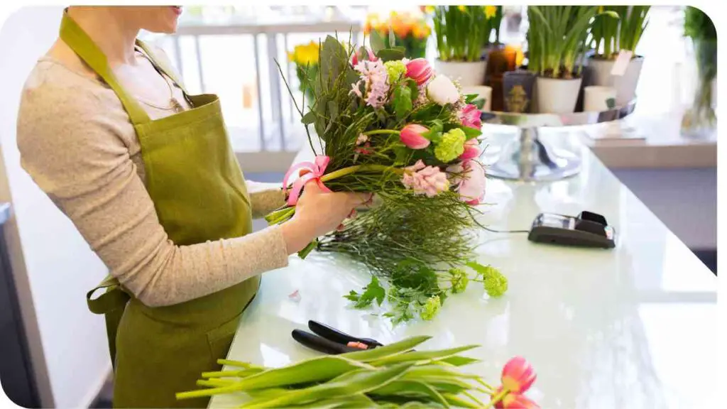 a person in an apron is holding a bouquet of flowers