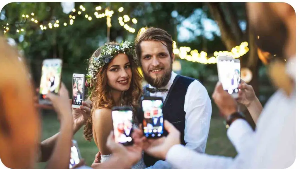 A bride and groom taking pictures with their cell phones