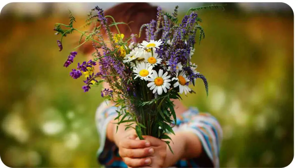 a child holding a bouquet of wildflowers